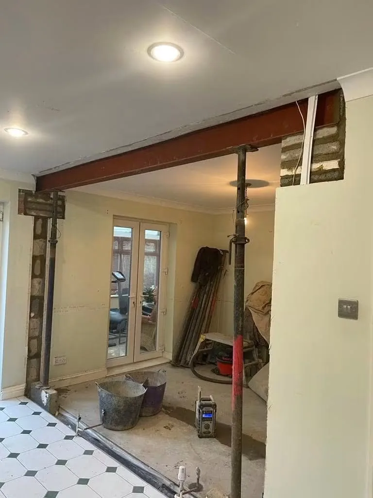 Structural steel beam installed above a widened internal opening with temporary supports in place