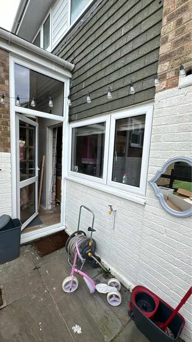 Rothwell kitchen before the alteration, with a narrow glazed door and adjoining window