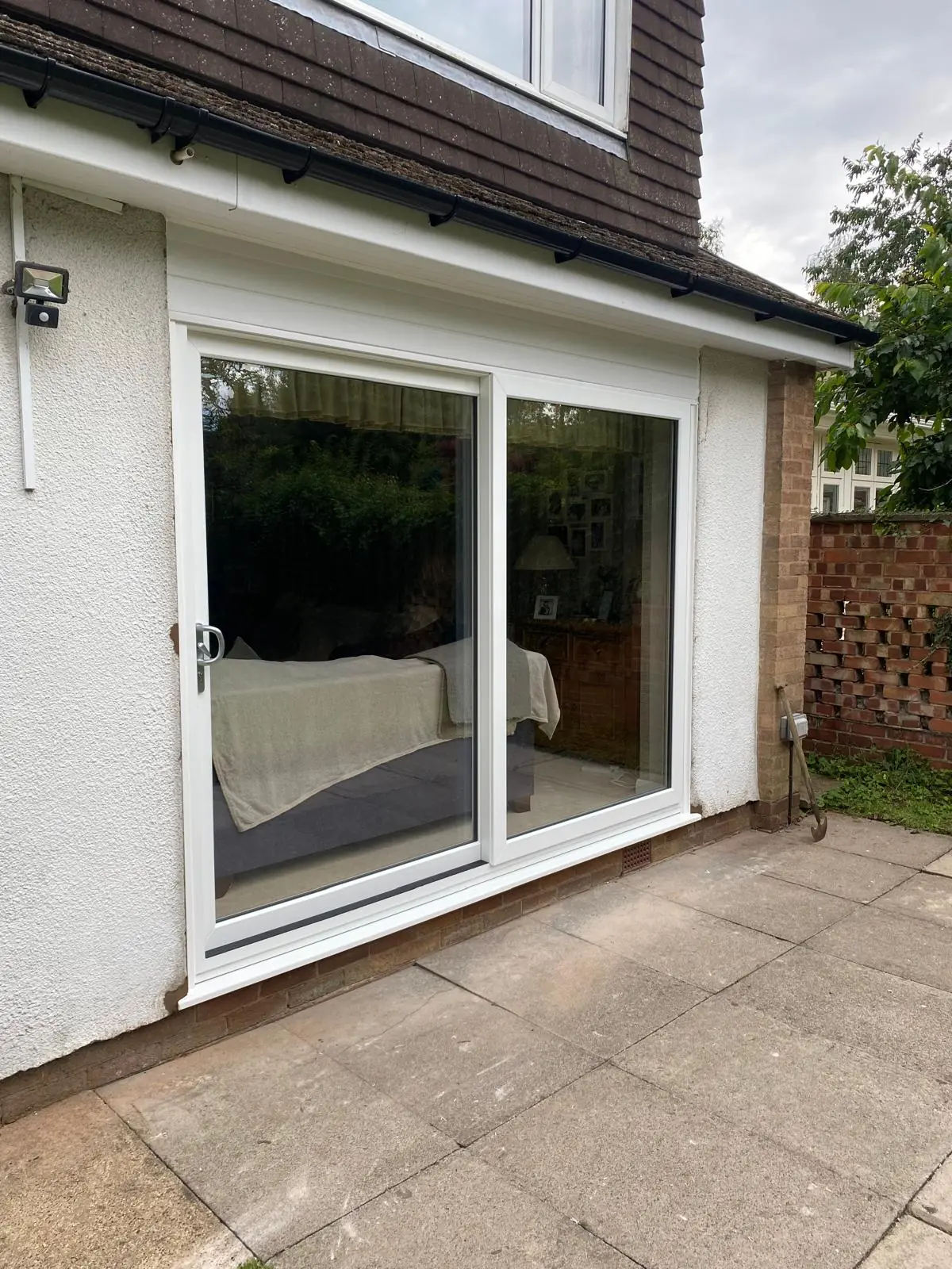 Kettering home after installation of white PVCu sliding patio doors and matching white cladding