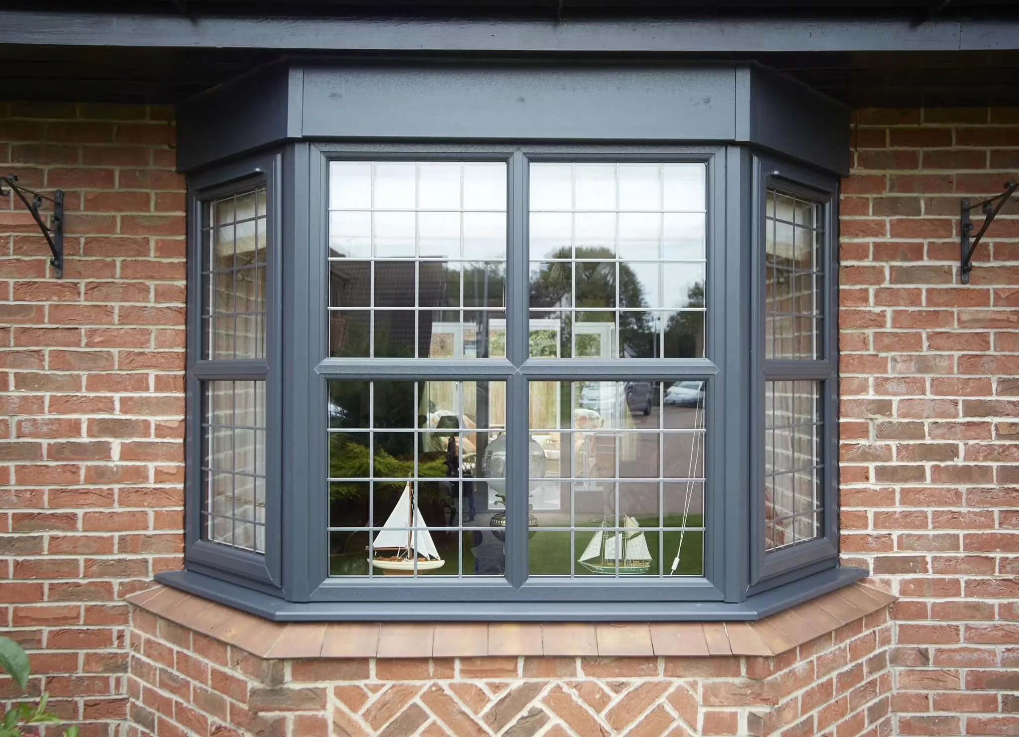 Grey casement bay window installed in brickwork