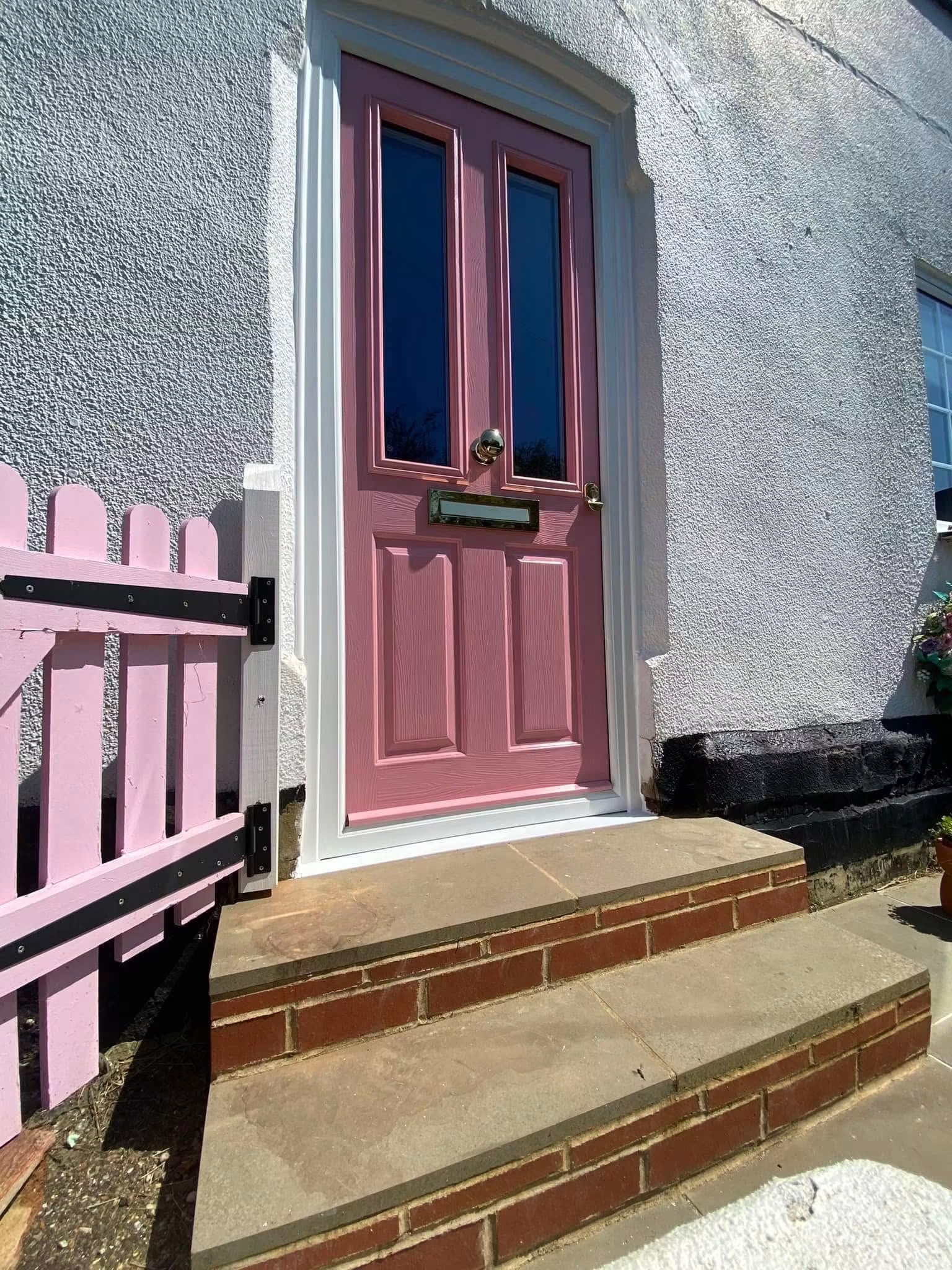 Pink timber-core composite entrance door with decorative glazing and polished hardware