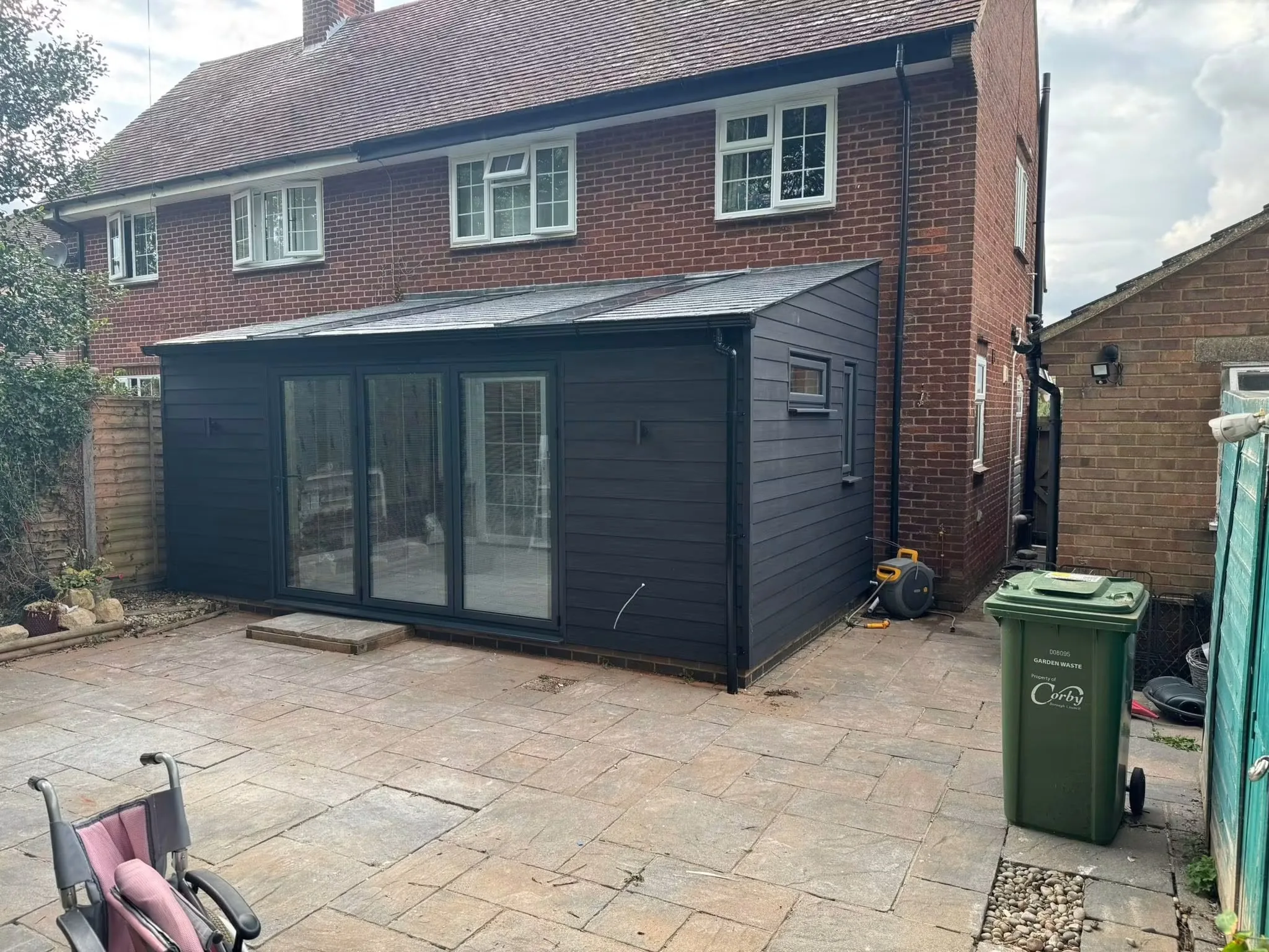 Completed East Carlton conservatory renovation with dark composite cladding, a warmer roof and bifold doors