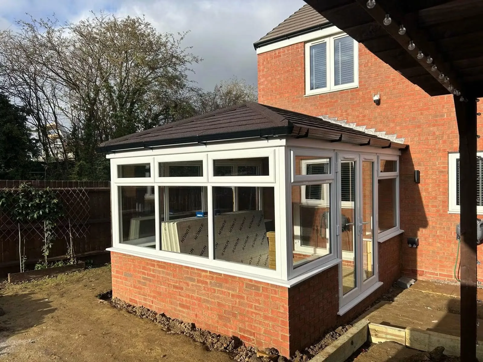 New rectangular conservatory with white frames and a tiled roof
