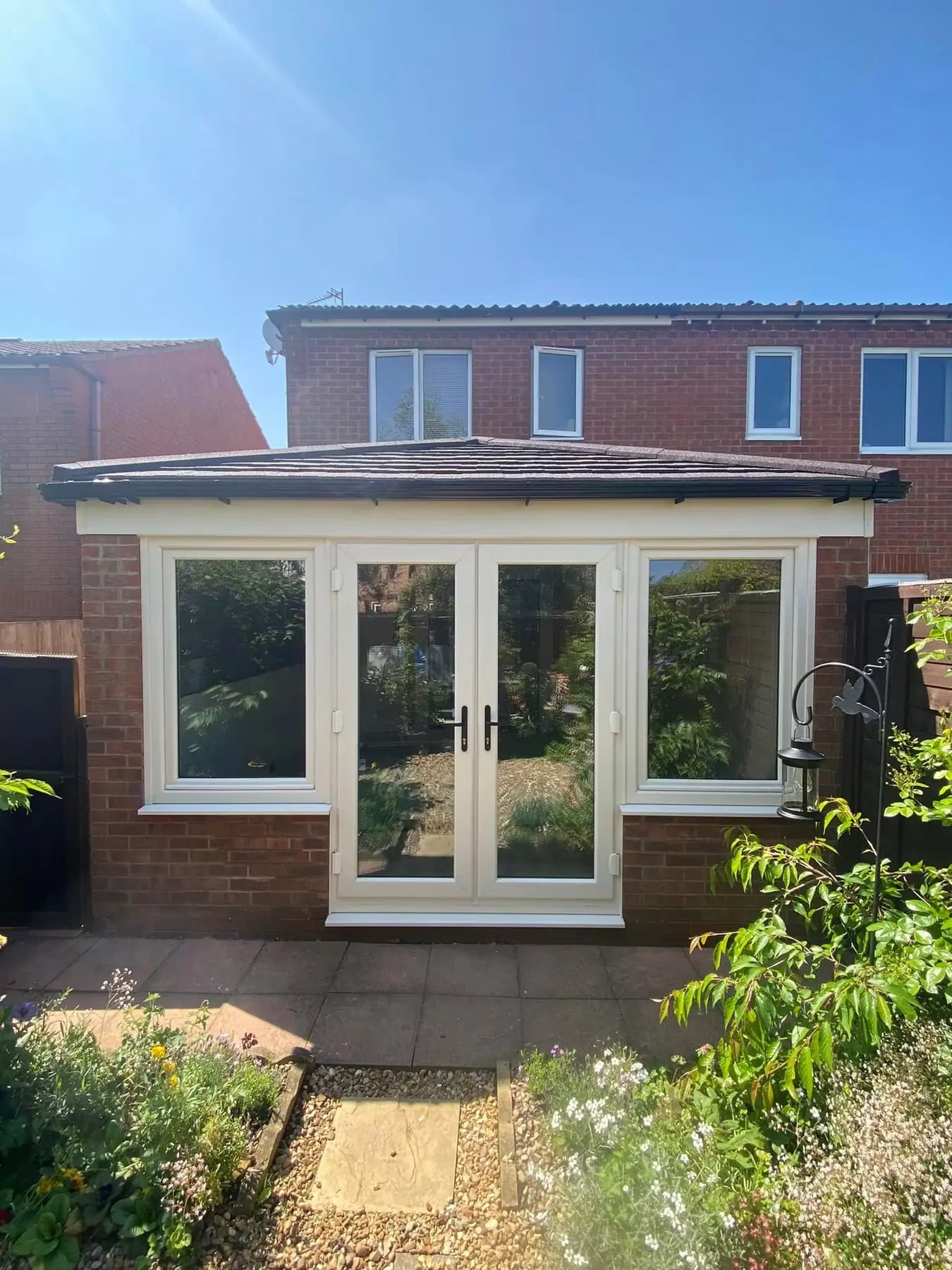 Renovated conservatory with a tiled warmer roof and white windows