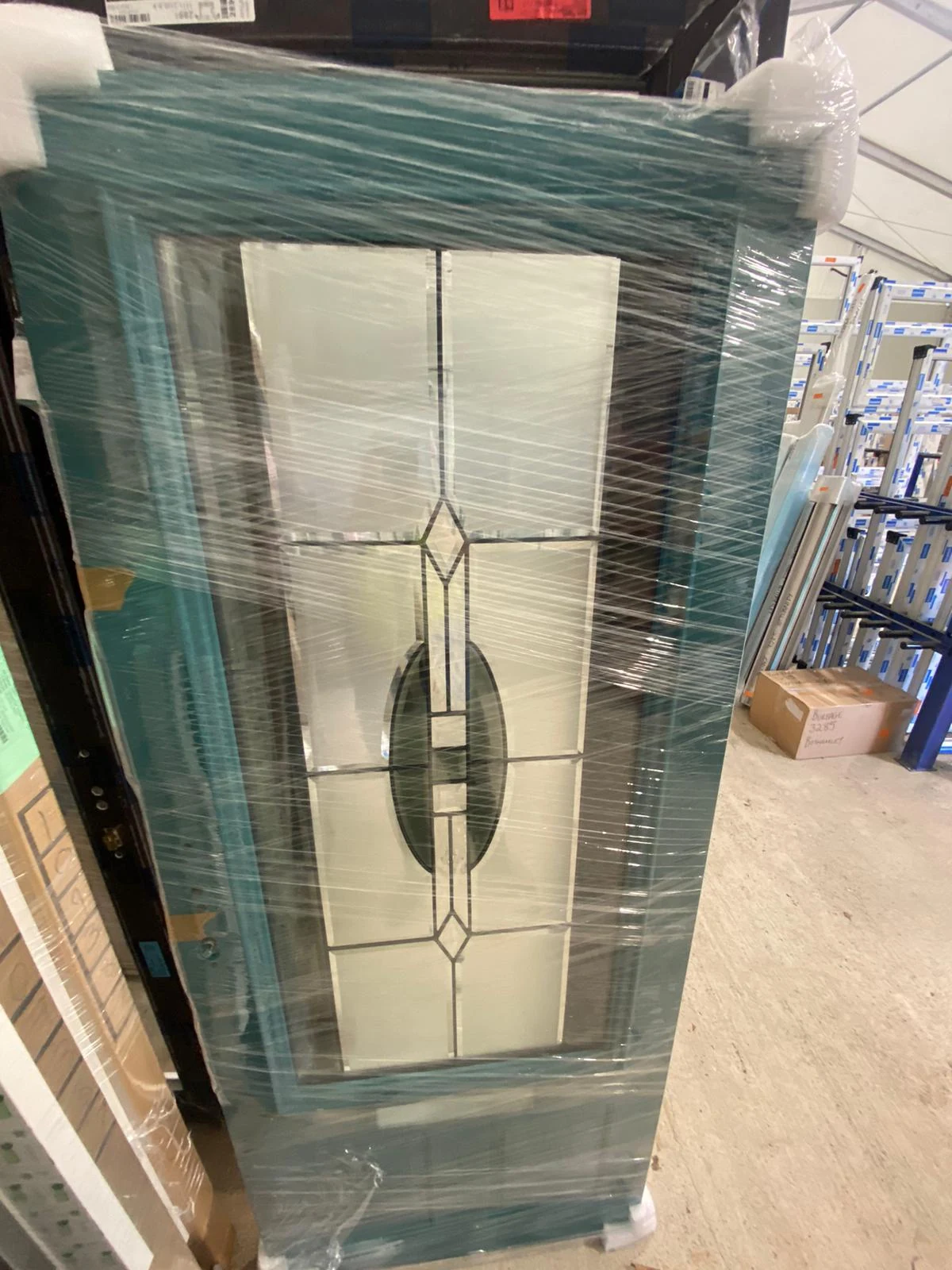 Custom teal entrance door wrapped and protected after manufacture