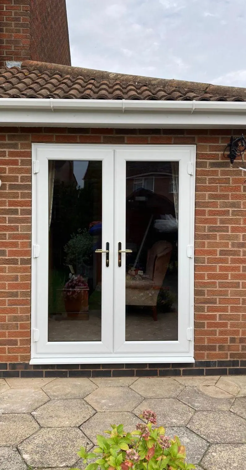 White PVCu French doors installed in a brick home