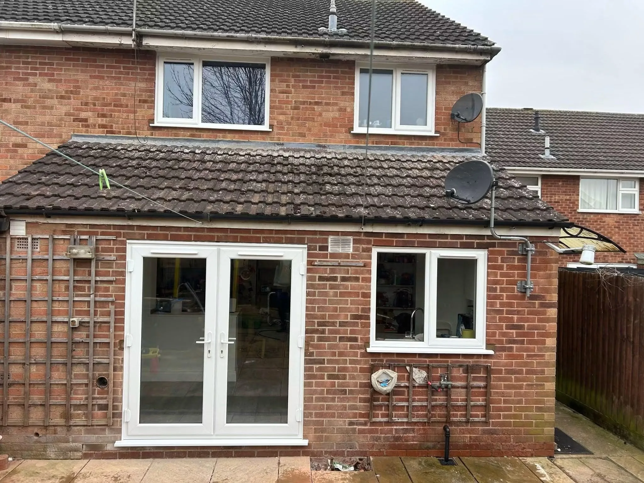 White French doors installed alongside matching windows
