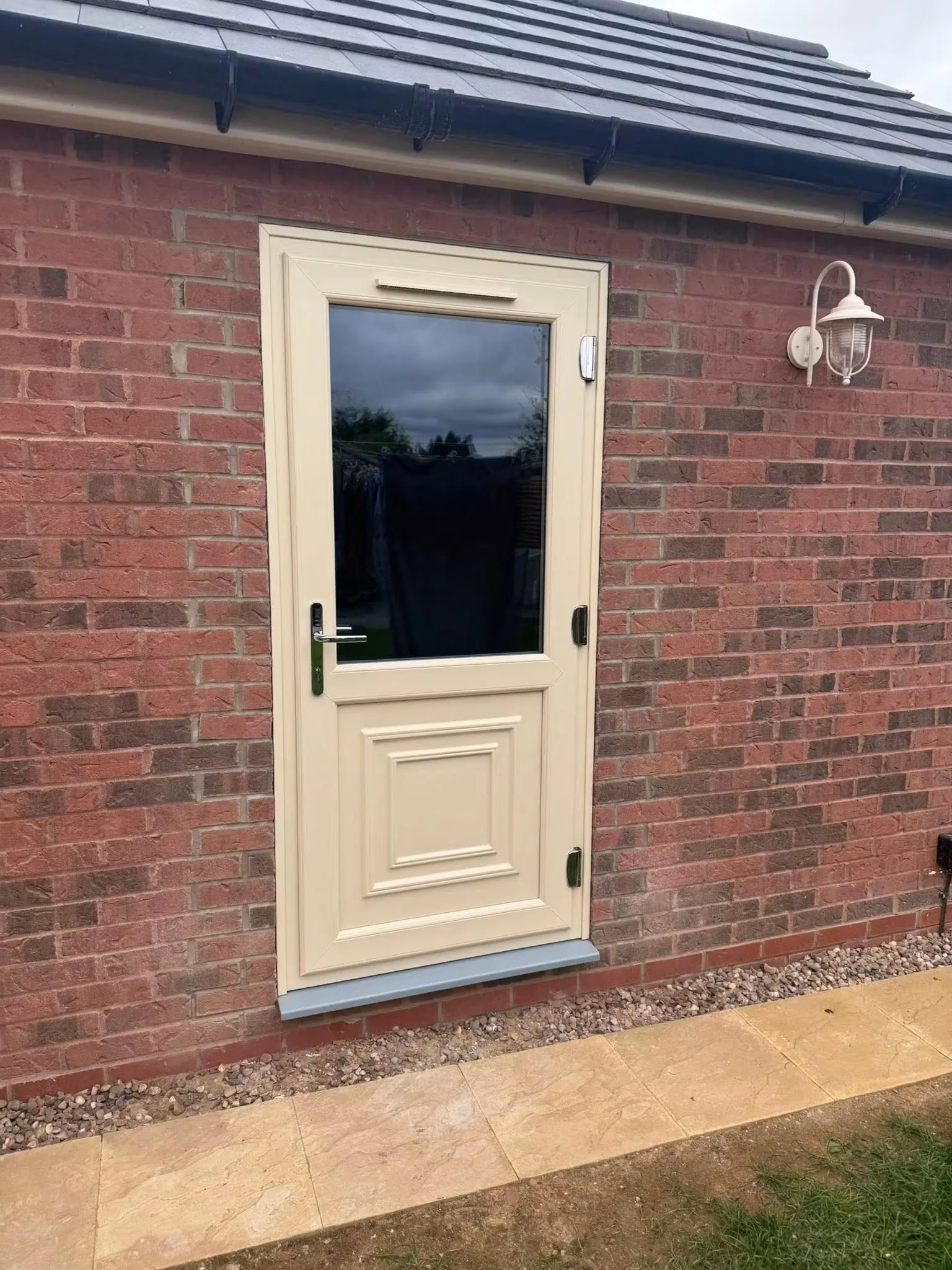 Cream PVCu entrance door installed in brickwork